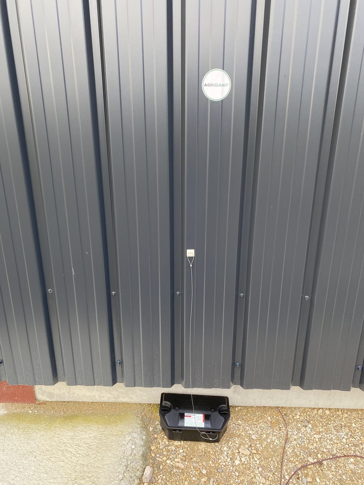 Poste d'appâtage sécurisé installé en extérieur contre un bâtiment industriel