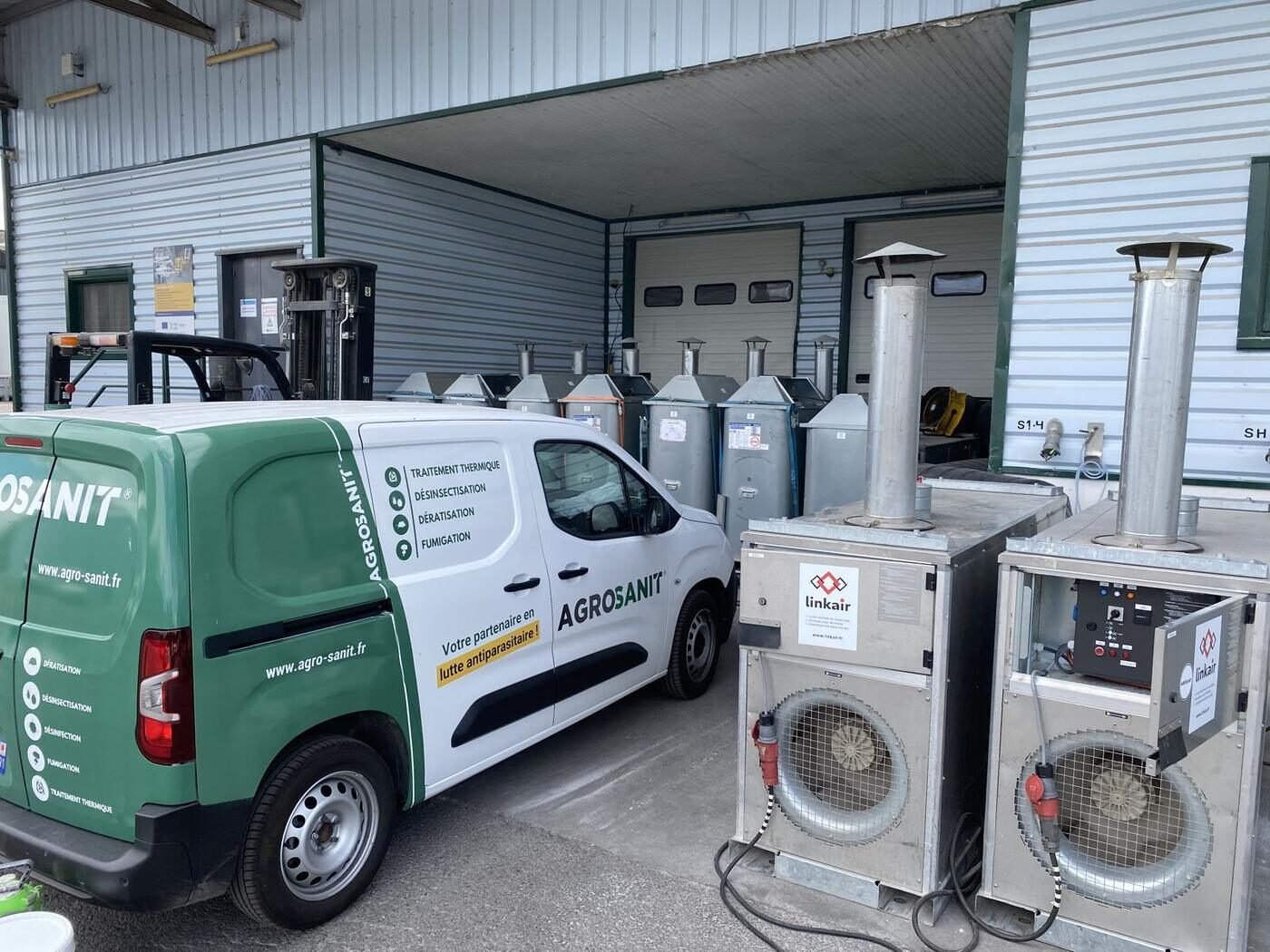 Véhicule Agrosanit et matériel de fumigation devant un hangar agricole